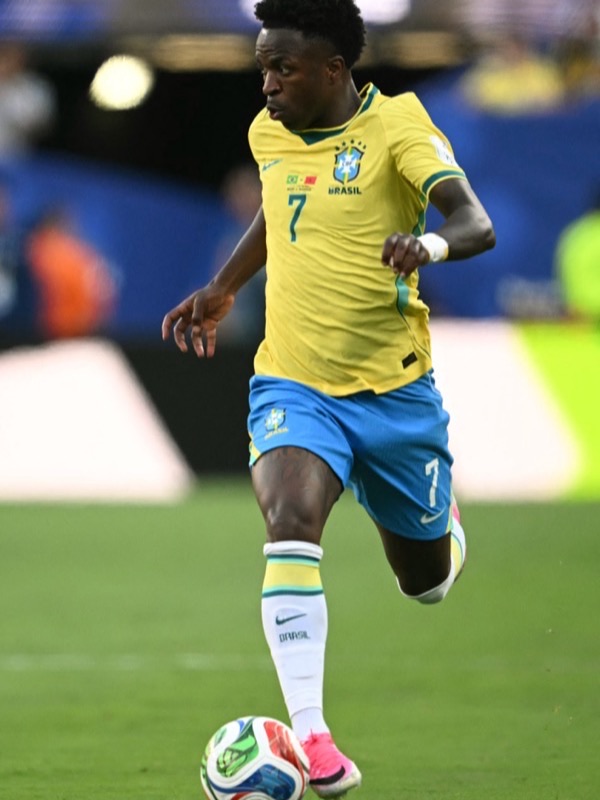 Jogador de futebol conduzindo a bola em campo